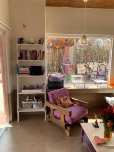 Una sala de estar con un sofá y una silla y una ventana. en Casa Voa-Voa, en Alto Paraíso de Goiás
