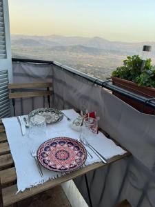 a table with plates of food on a balcony at B&b A casa di Lò CIN F3325 in Baunei