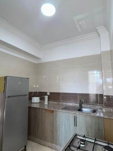 a kitchen with a sink and a refrigerator at Entre ville et détente- les portes de Guéliz in Marrakech