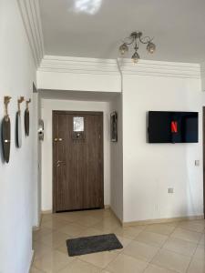 a hallway with a wooden door and a television on the wall at Entre ville et détente- les portes de Guéliz in Marrakech +12 photos