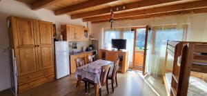 a kitchen with a table and a white refrigerator at Nika07 in Závažná Poruba