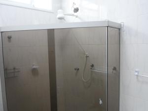 une salle de bain avec une douche avec une porte vitrée dans l'établissement Casa Centro de Bertioga - SP terrea 300 metros da praia - Marcondes 05, à Bertioga 57 autres photos