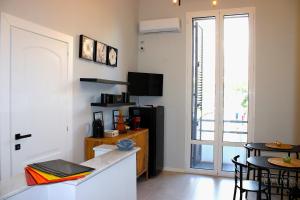 a kitchen with a refrigerator and a table with chairs at InCentro Elegant Rooms in Messina