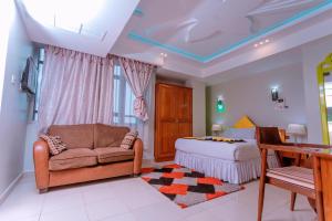 a bedroom with a bed and a couch and a table at Selig Hotel in Moshi