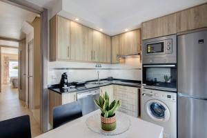 una cucina con mobili in legno e un tavolo con una pianta di Numar Residence A A a Vila Nova de Cacela