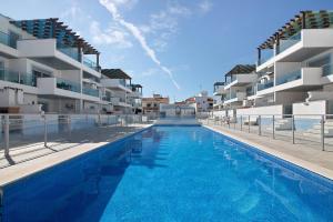 una piscina di fronte ad alcuni edifici di appartamenti di Numar Residence A A a Vila Nova de Cacela