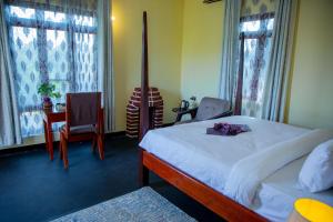 une chambre avec un lit, une table et des chaises dans l'établissement Helens Luxury Resort, à Karatu