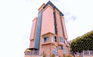 a tall pink building with a balcony at Selig Hotel in Moshi