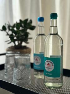 two bottles of water sitting on a table with a glass at Großes Apartment für 6 - Gasgrill Citynah Parken in Lippstadt