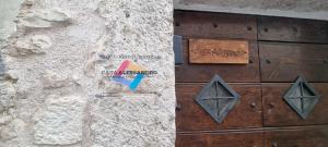 a wooden door with a sign on a stone wall at Casa Alessandro in Pacentro