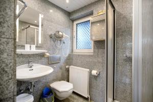 a bathroom with a sink and a toilet and a mirror at Sylt Ferienwohnung 2 Westerland in Westerland (Sylt) +15 photos