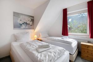 two beds in a small room with a window at Sylt Ferienwohnung 3 Westerland in Westerland (Sylt)