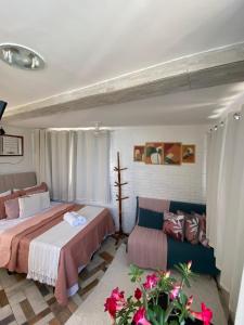 a bedroom with two beds and a couch at Apêzinho Vidigal - RJ in Rio de Janeiro