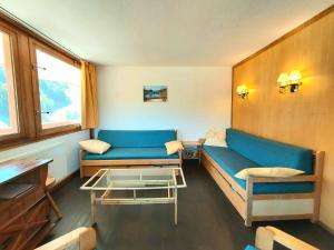 a living room with a blue couch and a table at Appartement spacieux à 2 chambres pour 8 personnes - Plagne Centre, proche des pistes, WIFI - FR-1-351-11 in La Plagne