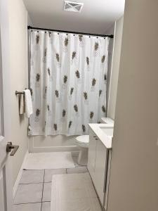 a bathroom with a shower curtain and a toilet at Serene Queen Room Shared Unit in Mississauga