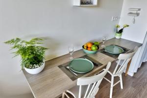 a dining room table with green plates and a bowl of fruit at Villeurbanne La Doua / Insa in Villeurbanne +23 photos