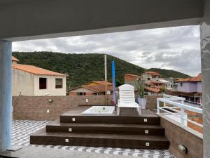 a white chair sitting on top of a roof at Aconchego do peró in Cabo Frio