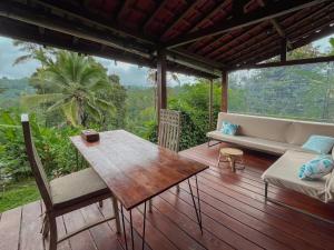 a wooden deck with a couch and a table at Sanda Plantation Hideaway in Sanda