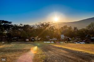 a dirt road with the sun setting in the background at Indabushe Eco Lodge in Schoemanskloof