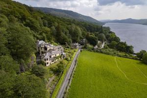 an aerial view of a house on a hill next to the water at Green Beck Cottage, within walking distance of the lake, shops, pubs & restaurants of Coniston in Coniston