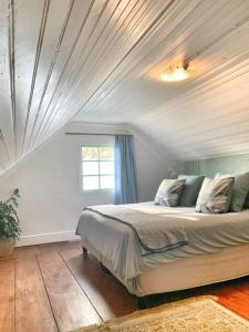 a bedroom with a large bed with a ceiling at The Town House - Lower Knysna Central in Knysna