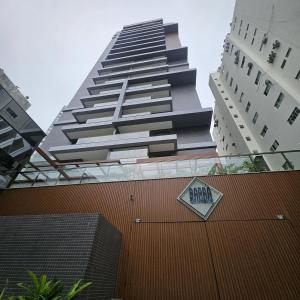 um prédio alto com uma placa na frente em Apto próximo à praia da Barra, com vista para o mar! em Salvador