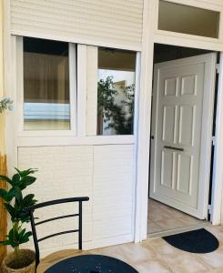 a front door of a house with a black chair at Cosy House Glyfada in Athens