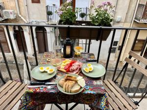 a table with food and eggs and bread on a balcony at Casa Roberto in Cefalù