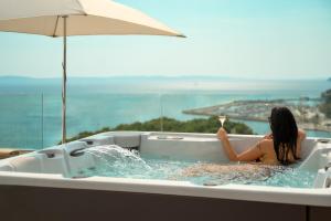 a woman in a bath tub with a glass of wine at Radisson Blu Resort & Spa in Split