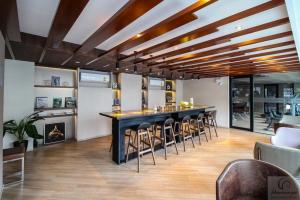 a room with a bar with stools and a fireplace at brown condo Phahon67 in Ban Chuat Plai Mai