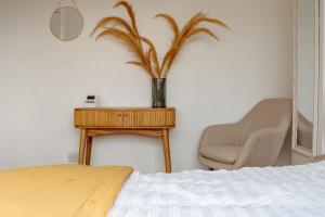 ein Schlafzimmer mit einem Tisch, einem Stuhl und einer Pflanze in der Unterkunft Modern Bright Spacious Home in Moortown