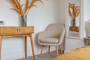 einen Stuhl neben einem Schreibtisch in einem Schlafzimmer in der Unterkunft Modern Bright Spacious Home in Moortown