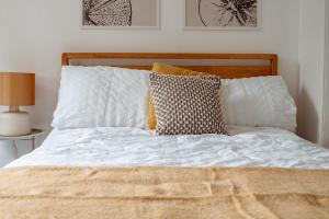 ein Bett mit weißen Laken und Kissen in einem Schlafzimmer in der Unterkunft Modern Bright Spacious Home in Moortown + 40 Fotos