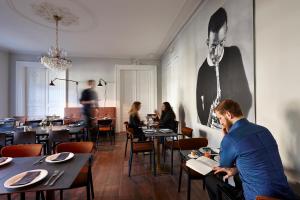 a man sitting at a table in a restaurant at Hotel Monsieur Ernest in Bruges
