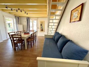 a living room with a couch and a table and chairs at Résidence Mes Amours d'Enfants - Les Villas du Lac in Soustons