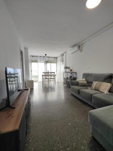a living room with a couch and a flat screen tv at Precioso apartamento residencial con vistas al mar in Puebla de Farnals +39 photos