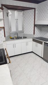 a kitchen with white cabinets and a sink at CASA LOZANO in Barreiros