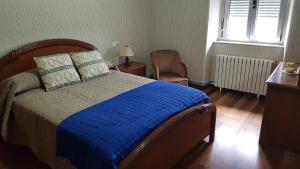 a bedroom with a bed and a window and a chair at CASA LOZANO in Barreiros