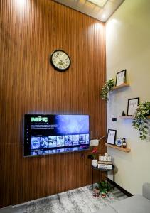 MetroNOOK Lucena Cozy Loft Type, AC, WI-FI,Netflix,Prime Video في لوسينا: ساعة على حائط خشبي مع تلفزيون