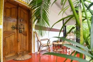 Un porche con una puerta de madera y una silla y una mesa. en Shoreline Marari Beach Villa at Golden Beach Mararikulam, en Mararikulam 33 fotos más