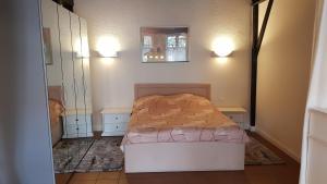 ein kleines Schlafzimmer mit einem Bett und einem Spiegel in der Unterkunft Altstadtloft Lüneburg in Lüneburg