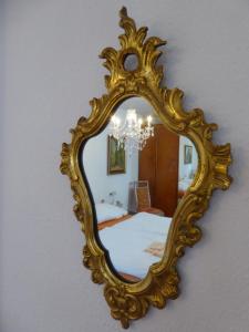 un miroir doré sur un mur dans une chambre dans l'établissement Ruhige, charmante Ferienwohnung "Im Erftal", à Eichenbühl 34 autres photos