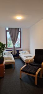 a room with two beds and a chair and a window at Ausblick Freital 3 in Freital