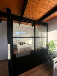 a bedroom with a large glass door with a bed at Triplex Loft Mountain ZONA BAJA in Sierra Nevada