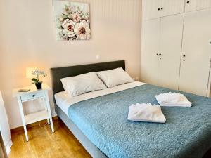 a bedroom with a bed with two white towels on it at Sun Beach Apartment in Anavyssos +11 photos