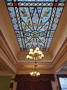 a stained glass ceiling in a room with a chandelier at Scarisbrick Hotel in Southport