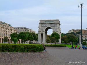 an arch in a city with buildings in the background at VITTORIA ROOMS GuestHouse - the Original since 2015 in Genoa