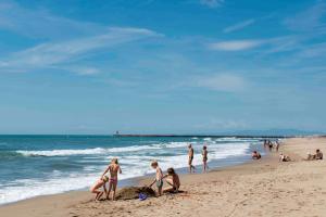 Un grupo de personas jugando en la arena de la playa. en Les Tamaris et Les Portes du Soleil, en Portiragnes