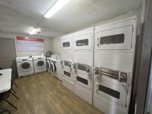 a laundry room with four washer and dryer machines at Red Roof Inn Corpus Christi North - Near Downtown in Corpus Christi