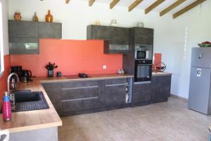 a kitchen with orange and gray cabinets and a refrigerator at Le Chalet des Rêves Ensoleillés in Saint-François +18 photos